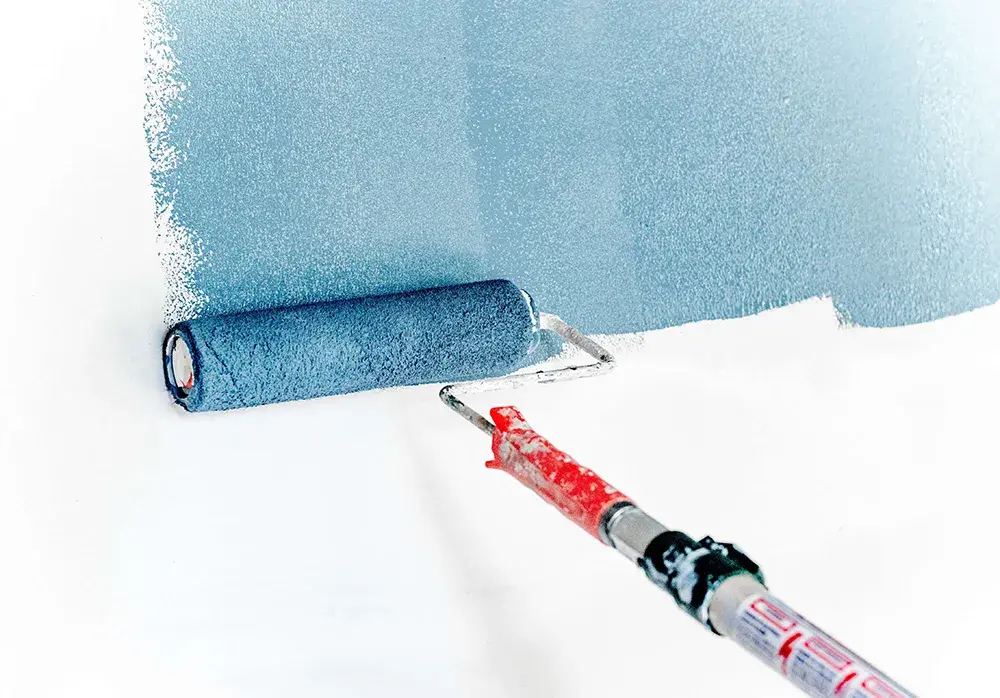 malowanie białej ściany na niebiesko za pomocą wałka